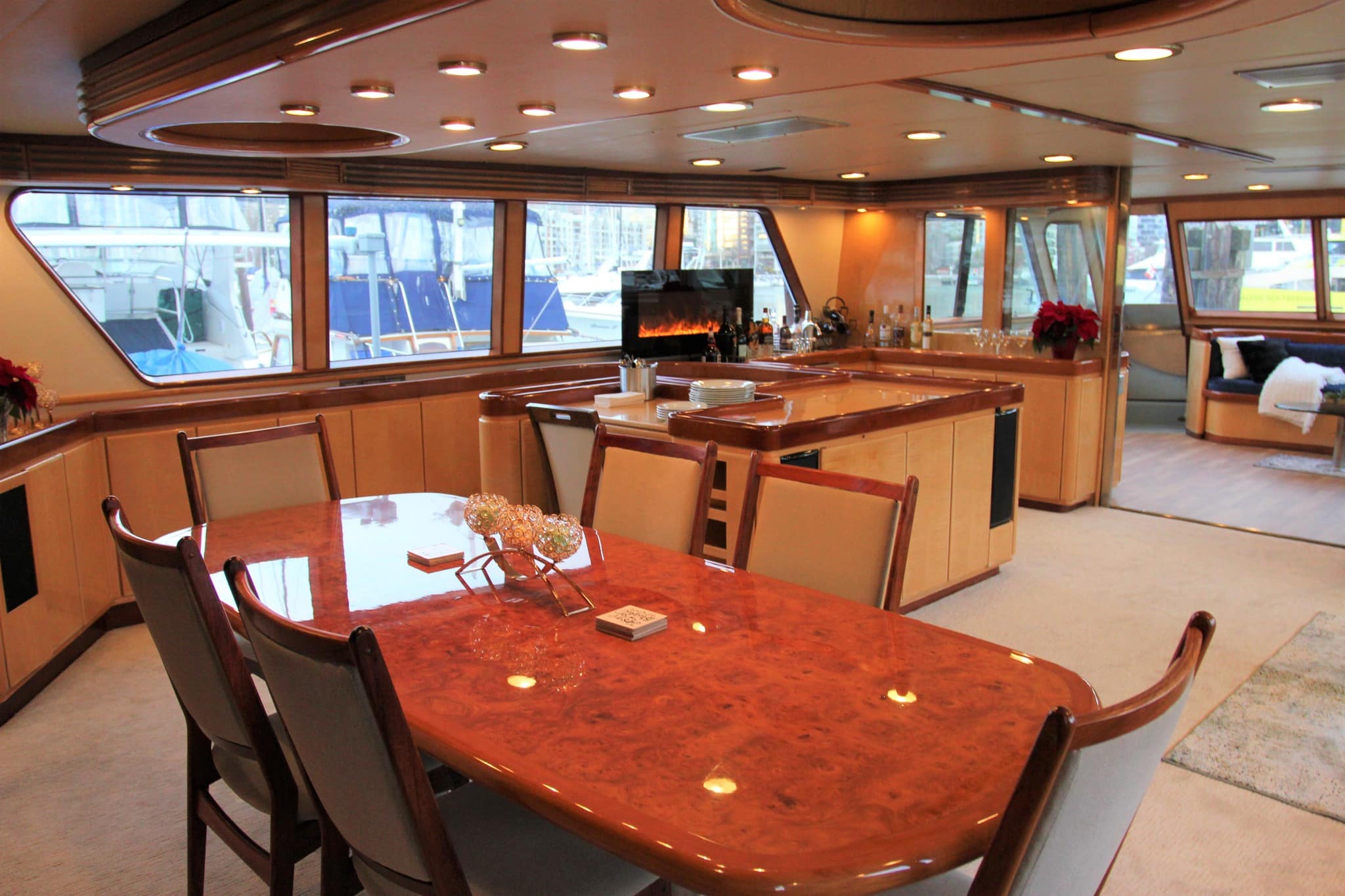 Interior of a luxury superyacht in BC. Beautiful polished wooden table, fireplace, and large windows.