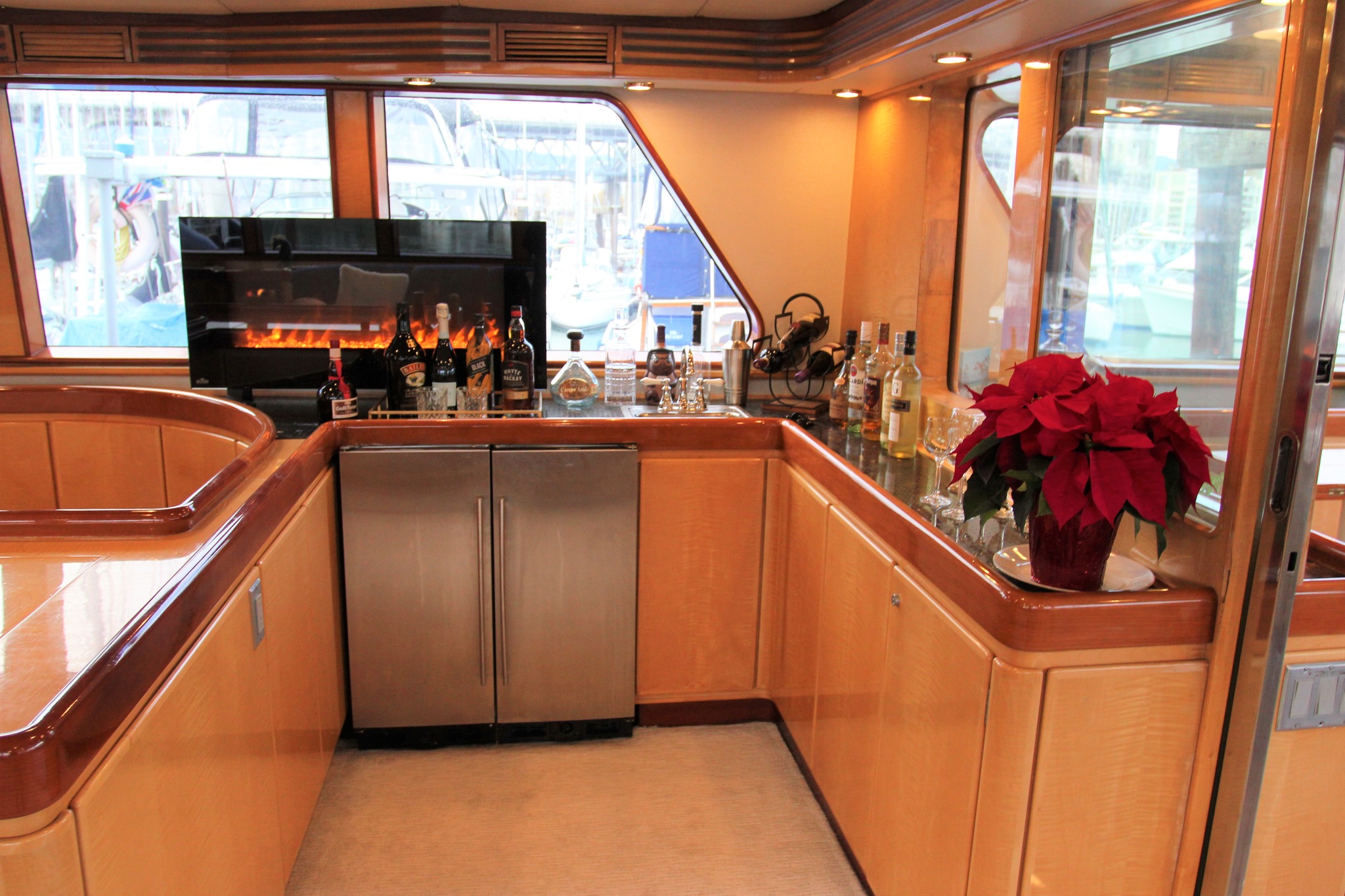 Bar area on a luxury yacht. Electric fireplace on the counter with a stainless steel fridge.