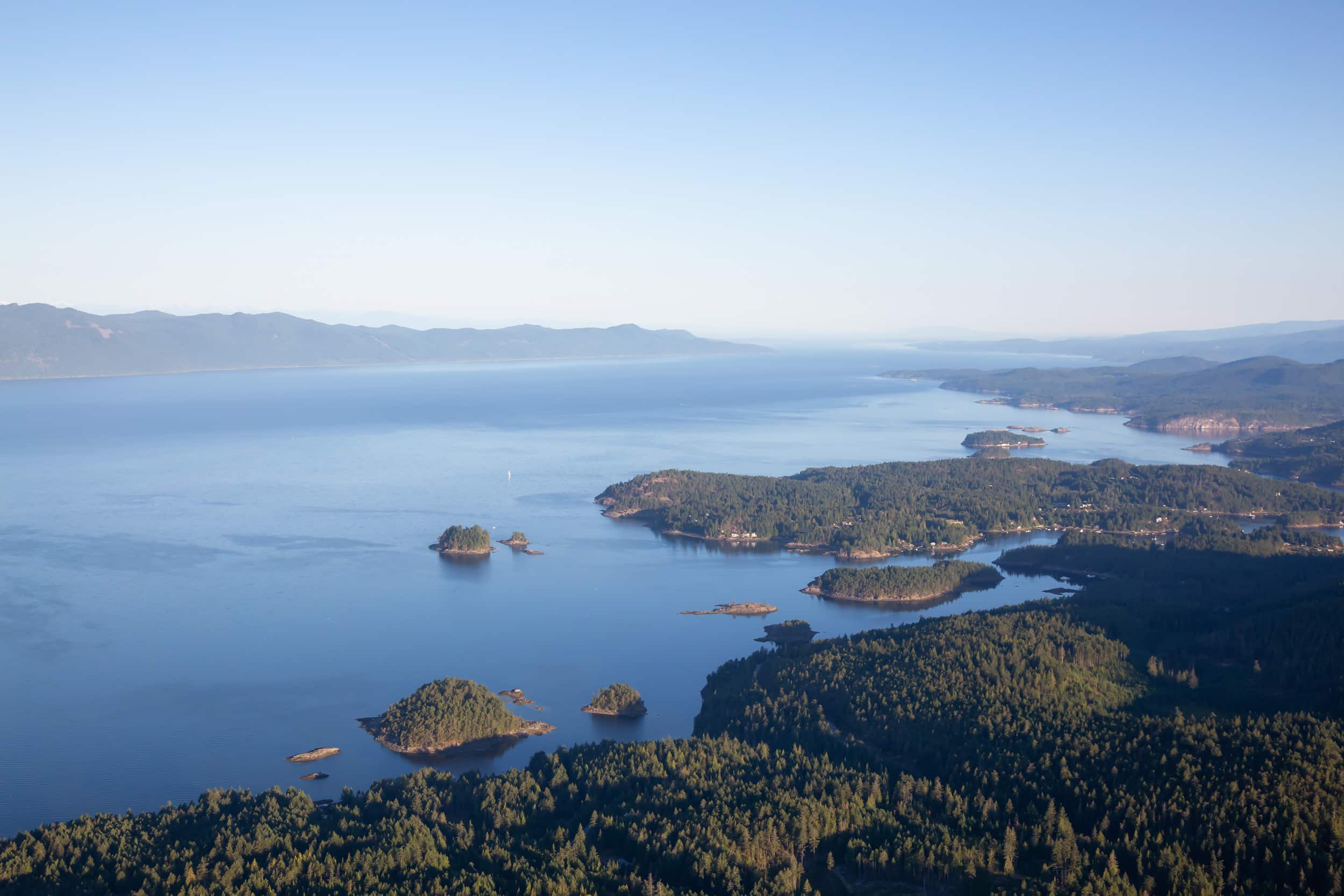 Aerial view of Madeira Park on the Sunshine Coast BC. Large blue waterway with small, forested islands along the coast.